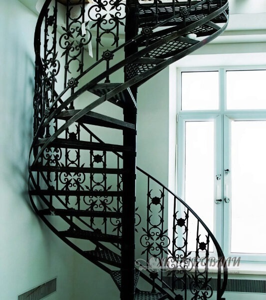 Кованая винтовая лестница со столбом и деревянными ступенями. Для дома на второй этаж
